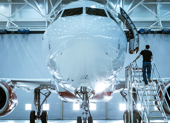 Technician inspecting an aircraft in a maintenance hangar