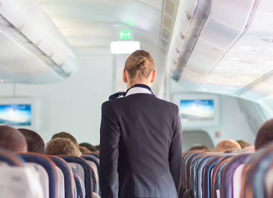 Cabin crew member walking the aisle during flight